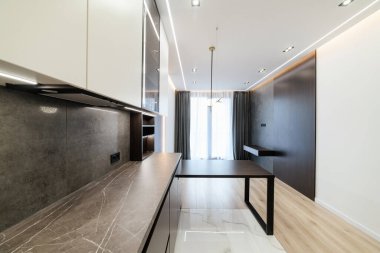 Geniş pencereli yeni bir evin içinde şık ve modern bir mutfak.