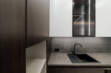Siyah lavabo, metal musluk ve cepheli yeni temiz mutfak.