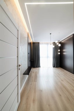 Beyaz kapıları ve siyah duvarları olan boş bir odanın içinde.