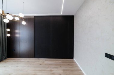 Beyaz ve siyah duvarlı oda ve ahşap zemin