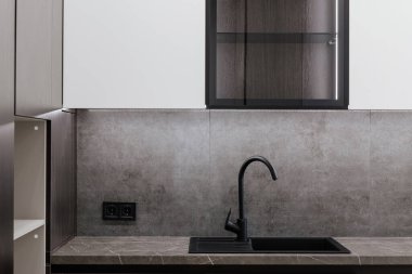 Gri tezgahlı yeni mutfak beyaz cephe ve koyu lavabo.