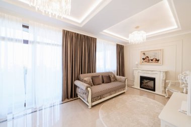 Işıklı oda, kanepe ve şömine.