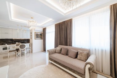 Konutun modern iç tasarımı. Kanepesi ve geniş pencereleri olan geniş bir oda.