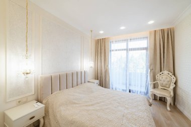 Geniş pencereli ve yataklı bir odanın modern iç tasarımı.