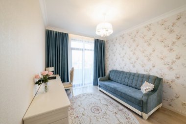 Mavi kanepesi ve geniş penceresi olan bir odanın modern iç tasarımı.