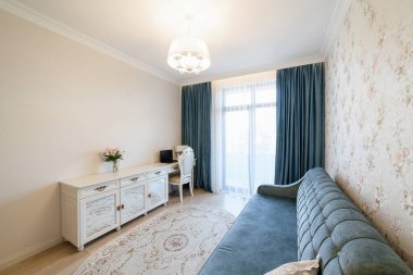 Odanın modern iç tasarımı. Mavi perdeleri ve bir kanepesi var.