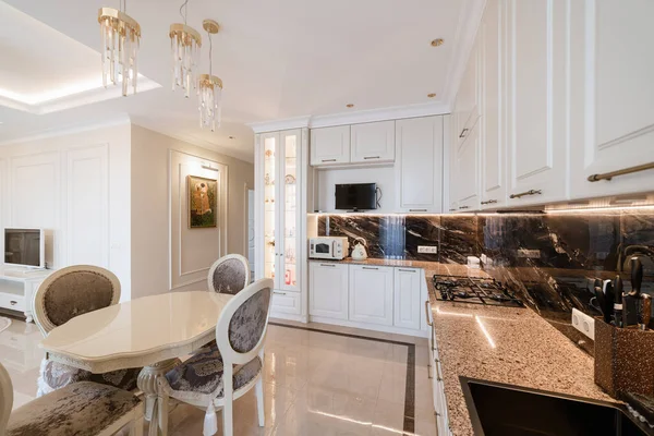 Odanın ve mutfağın beyaz mobilyalı modern iç tasarımı.