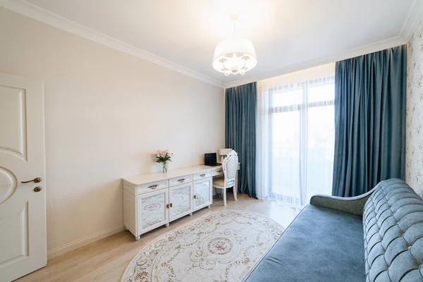 Mavi perdeli ve kanepeli bir odanın modern iç tasarımı.