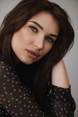 Beyaz arka planda koyu renk elbiseli güzel bir kızın fotoğrafı.