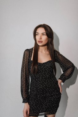 Beyaz arka planda siyah elbiseli bir kızın portresi.