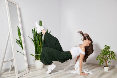 Şık bir genç kız bacağını aynanın önüne atıyor.