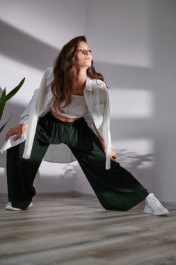 Beyaz bir arka planda güzel bir kız poz veriyor.