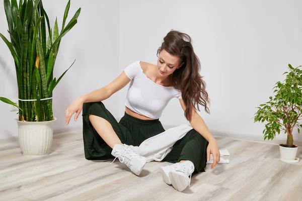 Genç kız yerde oturuyor, saçları açık.