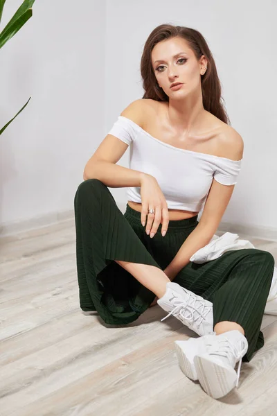 Menina Uma Camiseta Branca Calças Verdes Sentado Chão — Fotografia de Stock