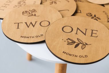 Beyaz bir masanın üzerinde yuvarlak tahta tahtalar üzerinde bir ve iki yazıları var.