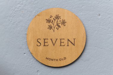 Ahşap yuvarlak tahta üzerinde gri arkaplanda yedi yazılıydı.