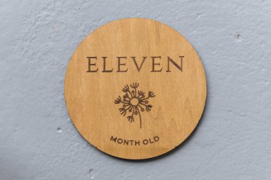 Ahşap yuvarlak tahta. Üzerinde 11 yazılıydı. Gri arka plan.