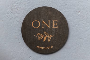 Koyu ahşap yuvarlak tahta üzerinde gri arkaplan yazılı olan.