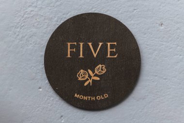 dark wooden round board with the inscription five on a gray background