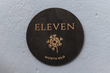 Koyu ahşap yuvarlak tahta. Üzerinde 11 yazılıydı.