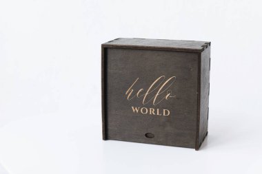 Üzerinde beyaz bir arkaplan yazılı koyu renkli ahşap kutu.