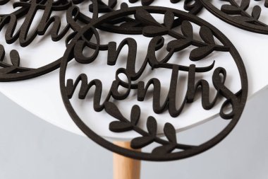 Beyaz arka planda ilk ay yazılı ahşap bir tahta oyulmuş.