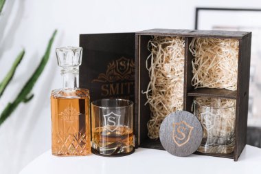 decanter and glass of whiskey on a white table. set for whiskey in a wooden box