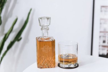 glass beaker and decanter with whiskey on a white table