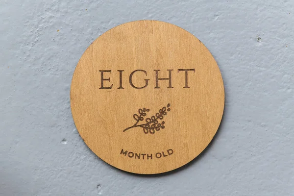 Gri arkaplanda sekiz yazılı ahşap yuvarlak tahta.