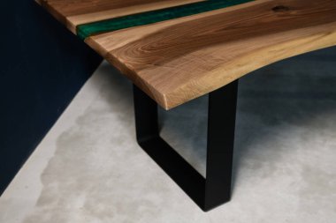Doğal ahşaptan ve yeşil epoksiden yapılmış bir masa.