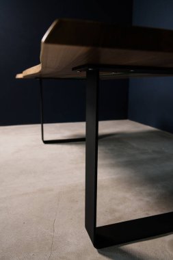 Siyah metal bacaklı doğal ahşap masa.