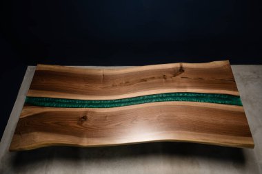 Doğal ahşap ve epoksi reçine kenarından yapılmış büyük sert bir masa.