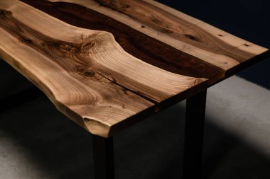 Ahşap ve kırmızı epoksiden yapılmış koyu renkli bir masa.