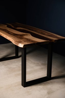 Doğal ahşaptan ve metal bacaklardaki epoksi reçineden yapılmış bir masa.