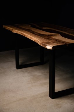 Siyah bacaklı, doğal ahşaptan yapılmış büyük, güzel bir masa.