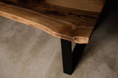 Siyah metal bacaklı doğal bir ağaçtan masa kenarına.