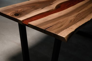 Katı ahşaptan ve kırmızı epoksiden yapılmış bir masa.