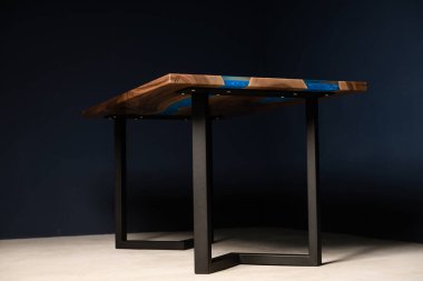 Tahtadan ve epoksiden yapılmış metal bacaklı büyük bir masa.