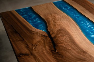 Doğal ahşap ve mavi epoksi reçineden yapılmış masa örtüsü.