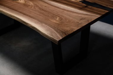 Doğal ahşaptan yapılmış masa ve mavi arka planda şeffaf epoksi.