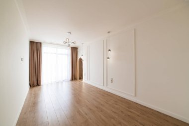 Geniş pencereli ve ahşap zeminli bir odanın parlak iç tasarımı