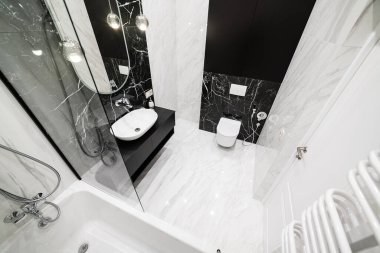 Yeni bir evde aydınlık ve koyu fayanslı bir banyonun iç tasarımı.