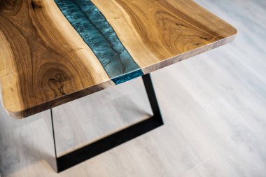 Doğal ahşaptan ve siyah epoksiden yapılmış bir masa.