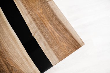 Doğal ahşaptan ve siyah epoksiden yapılmış bir masa.