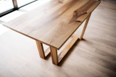 Doğal ahşap masa iç kısımda tahta bacaklar üzerinde.
