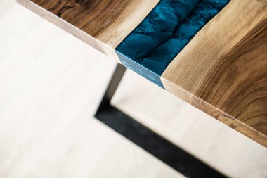 Doğal ahşaptan ve mavi epoksiden yapılmış bir masa.