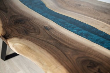 Doğal ahşaptan ve mavi epoksiden yapılmış bir masa.