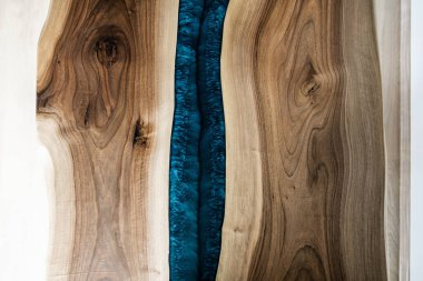 Doğal ahşaptan ve mavi epoksiden yapılmış bir masa.