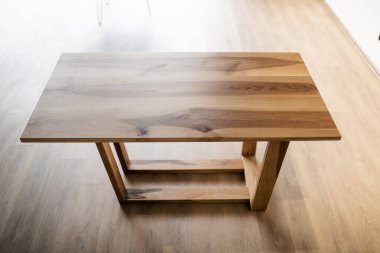 Doğal ahşap masa iç kısımda tahta bacaklar üzerinde.