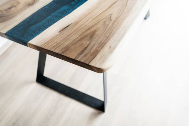 Doğal ahşaptan ve mavi epoksiden yapılmış bir masa.